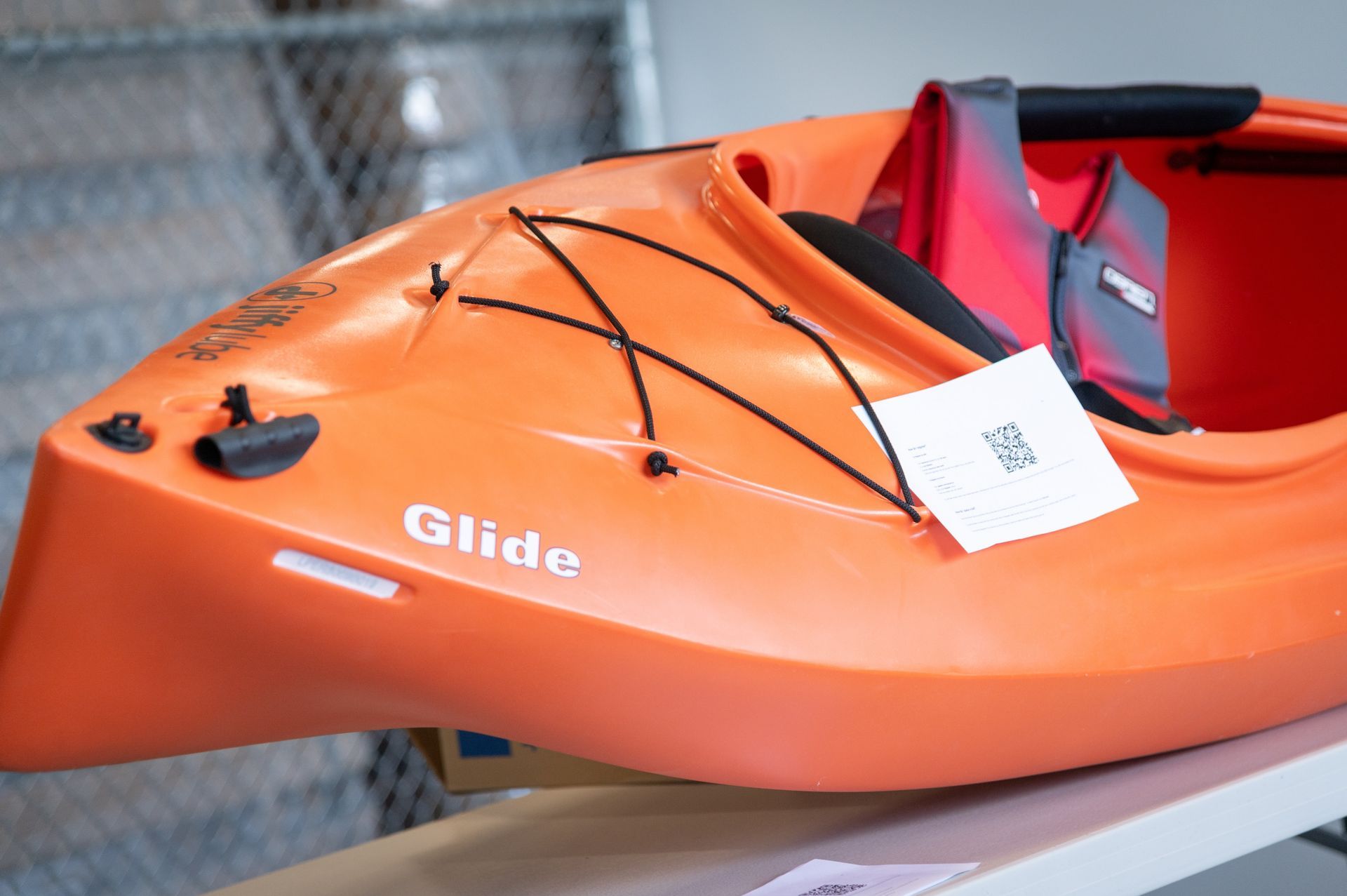 An orange glide kayak is sitting on a table