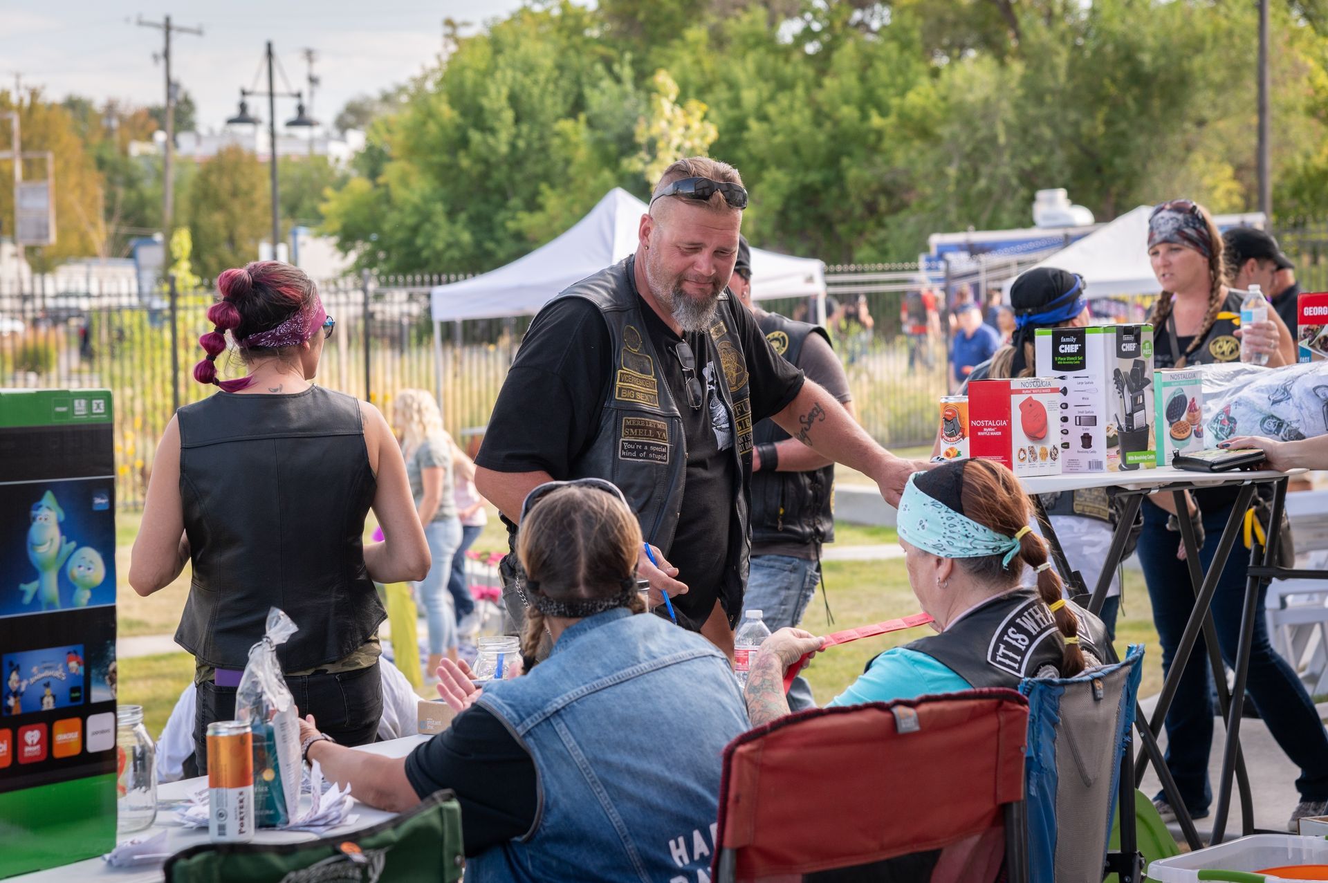 A group of people are standing around a table at a festival.