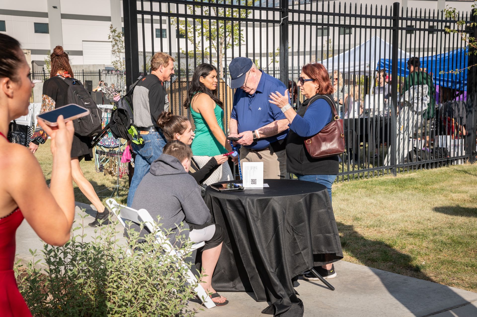 A woman is taking a picture of a group of people standing around a table.