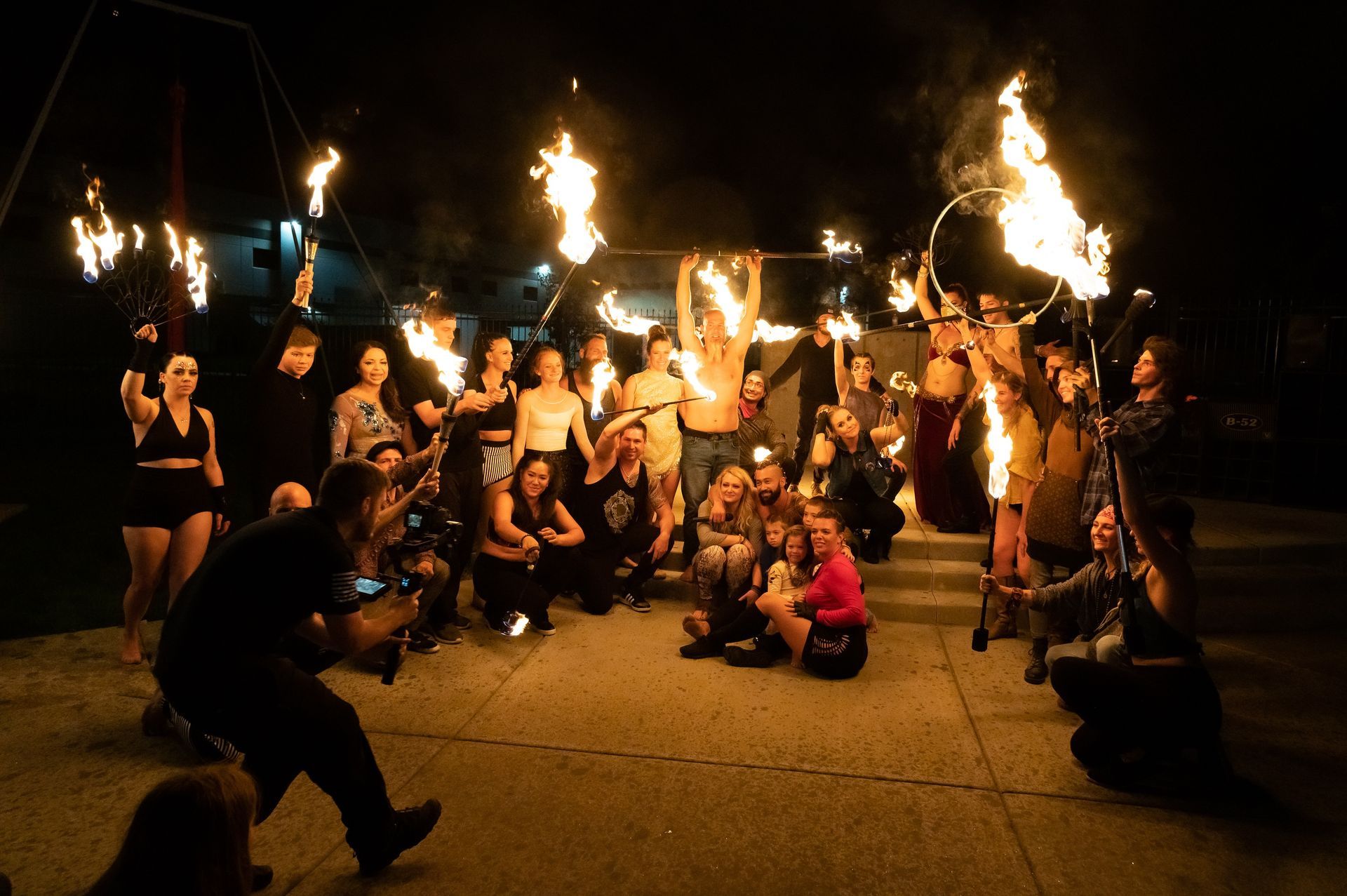 A group of people are posing for a picture with fire torches.