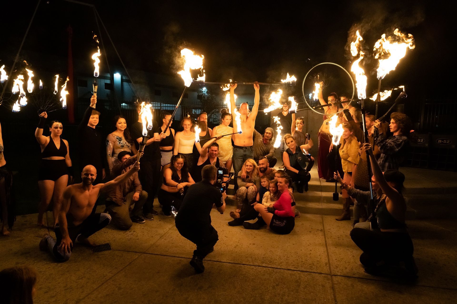 A group of people are posing for a picture with fire sticks.