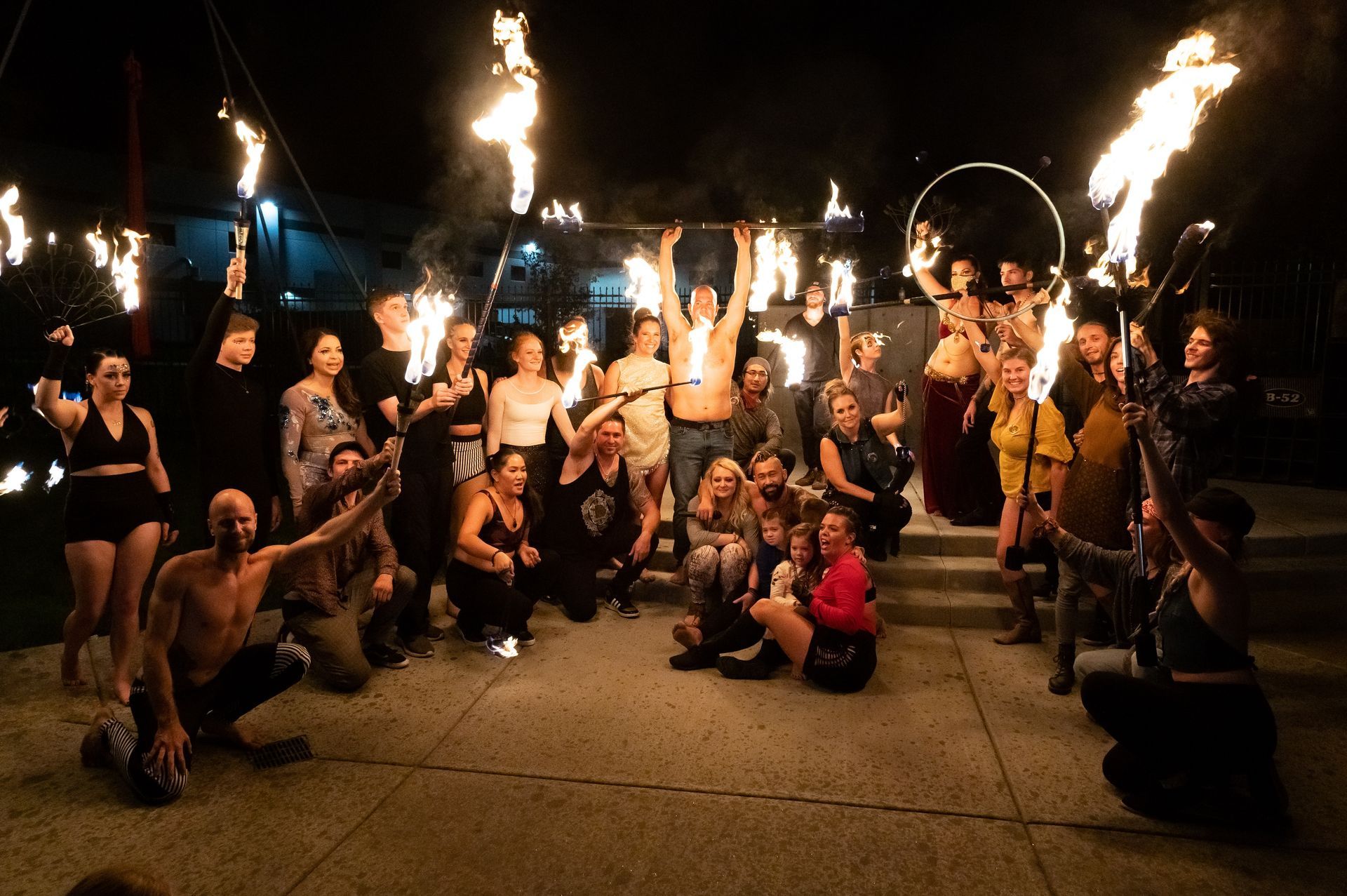 A group of people are posing for a picture with fire in their hands.