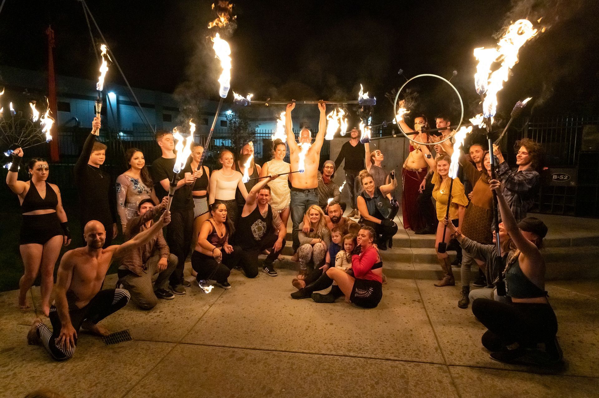 A group of people are posing for a picture with fire in their hands.