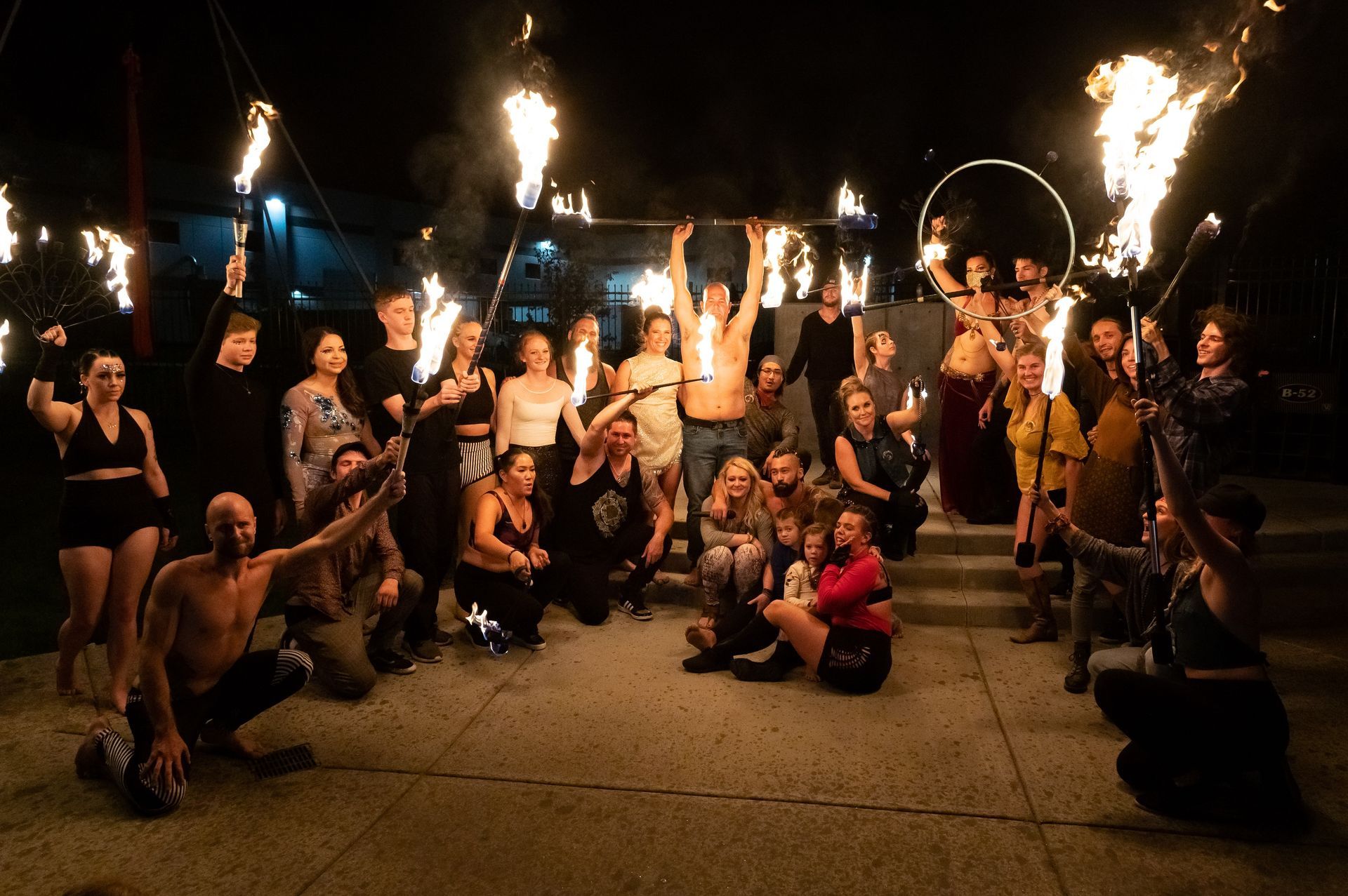 A group of people are posing for a picture with fire torches.