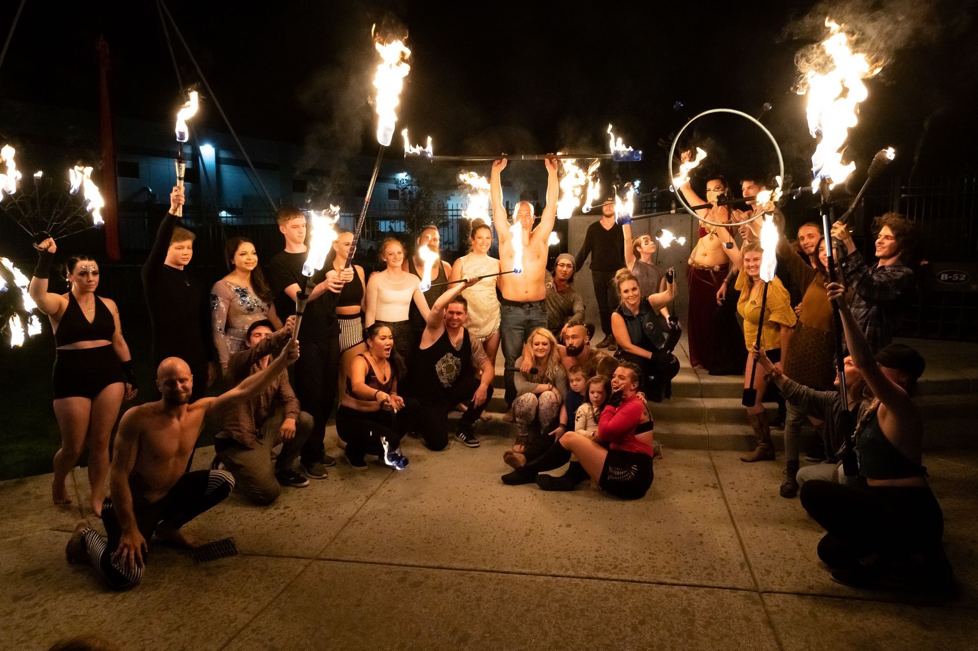A group of people are posing for a picture with fire sticks.