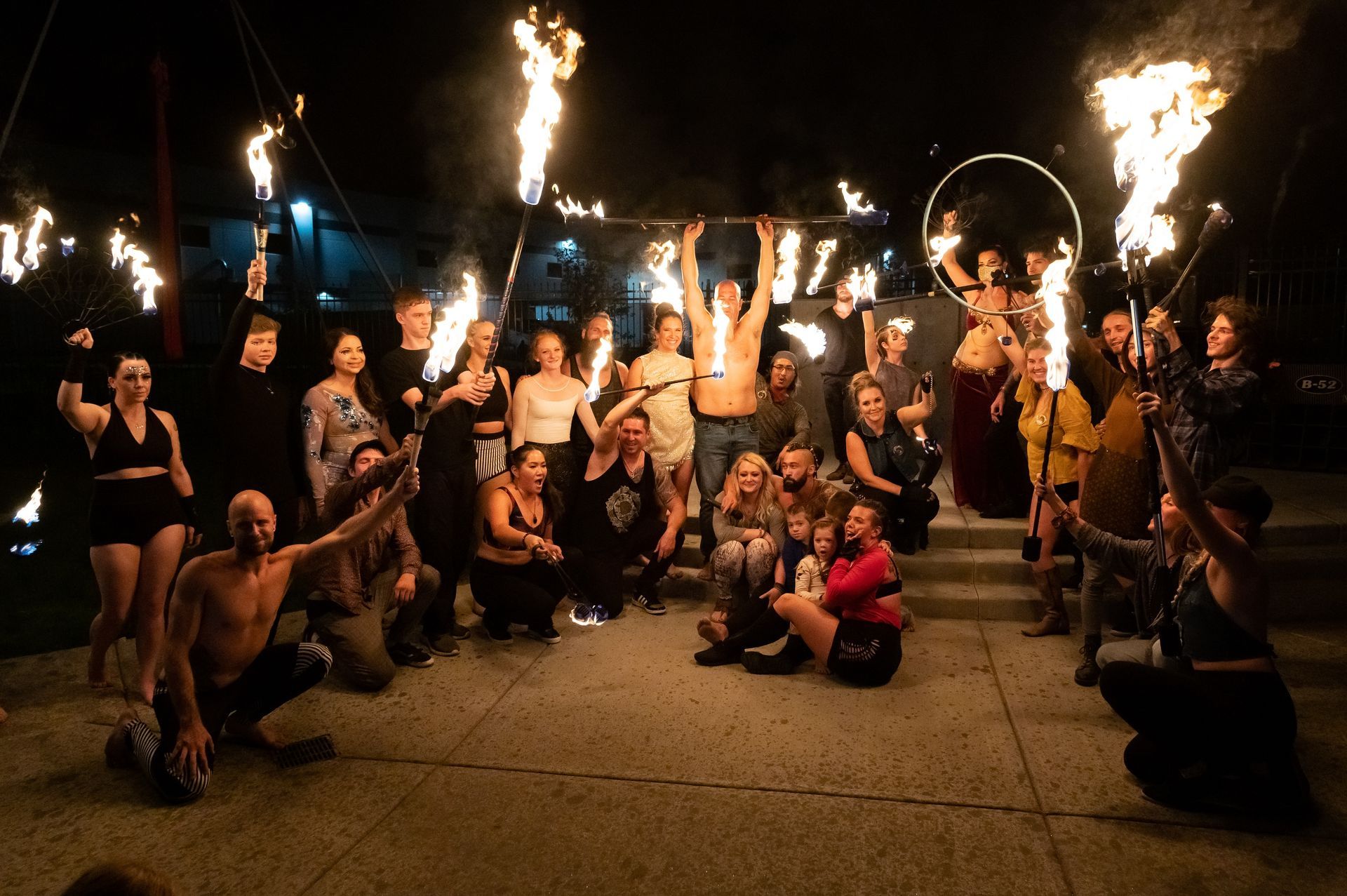 A group of people are posing for a picture with fire torches.