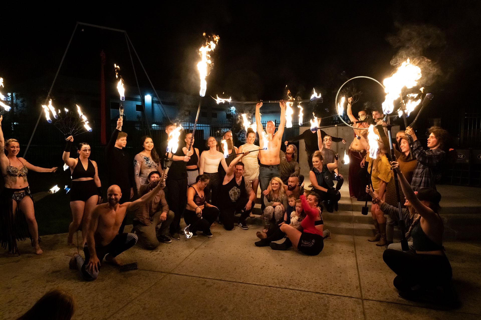 A group of people are posing for a picture with fire in their hands.