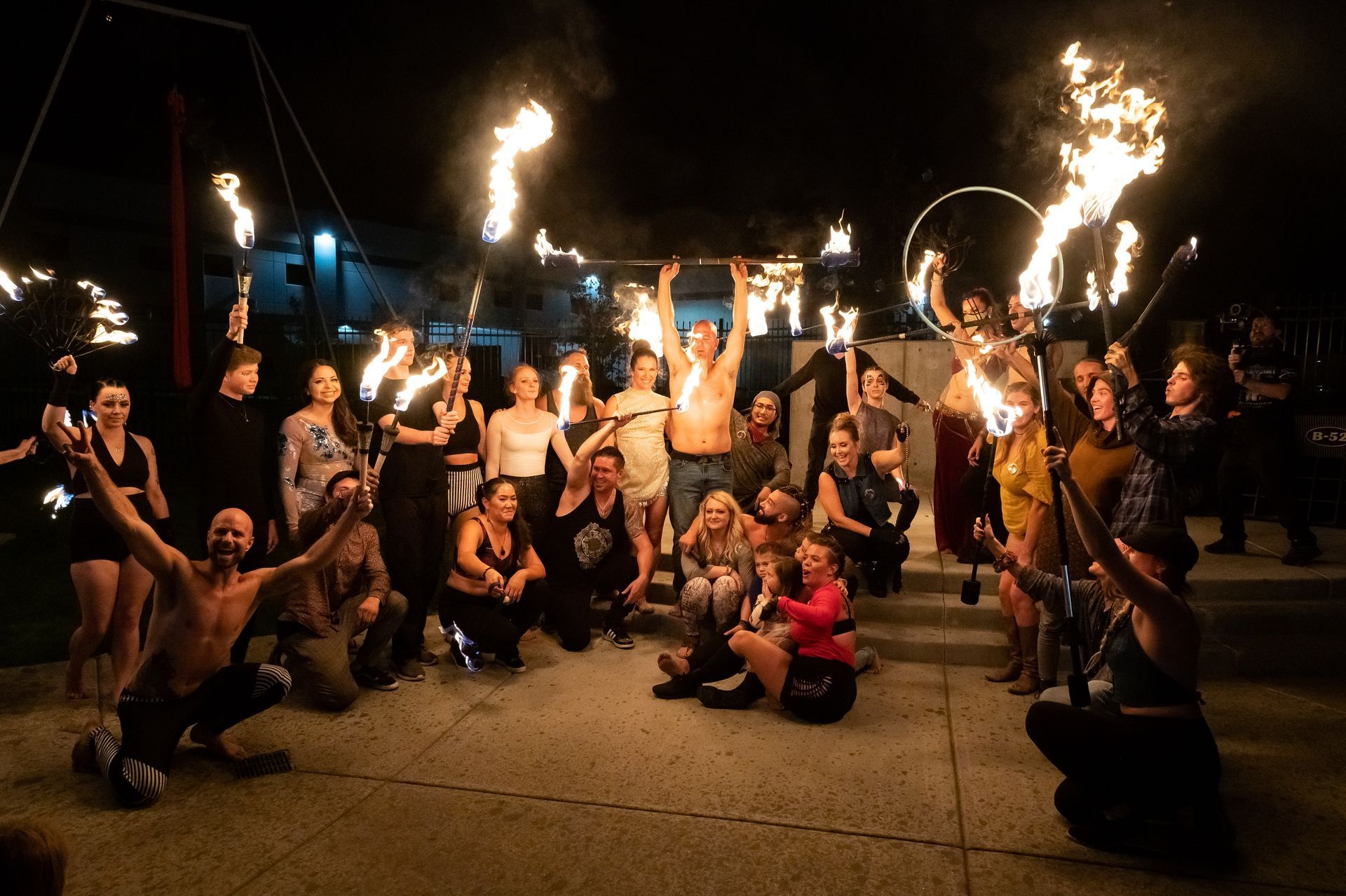 A group of people are posing for a picture while holding fire torches.