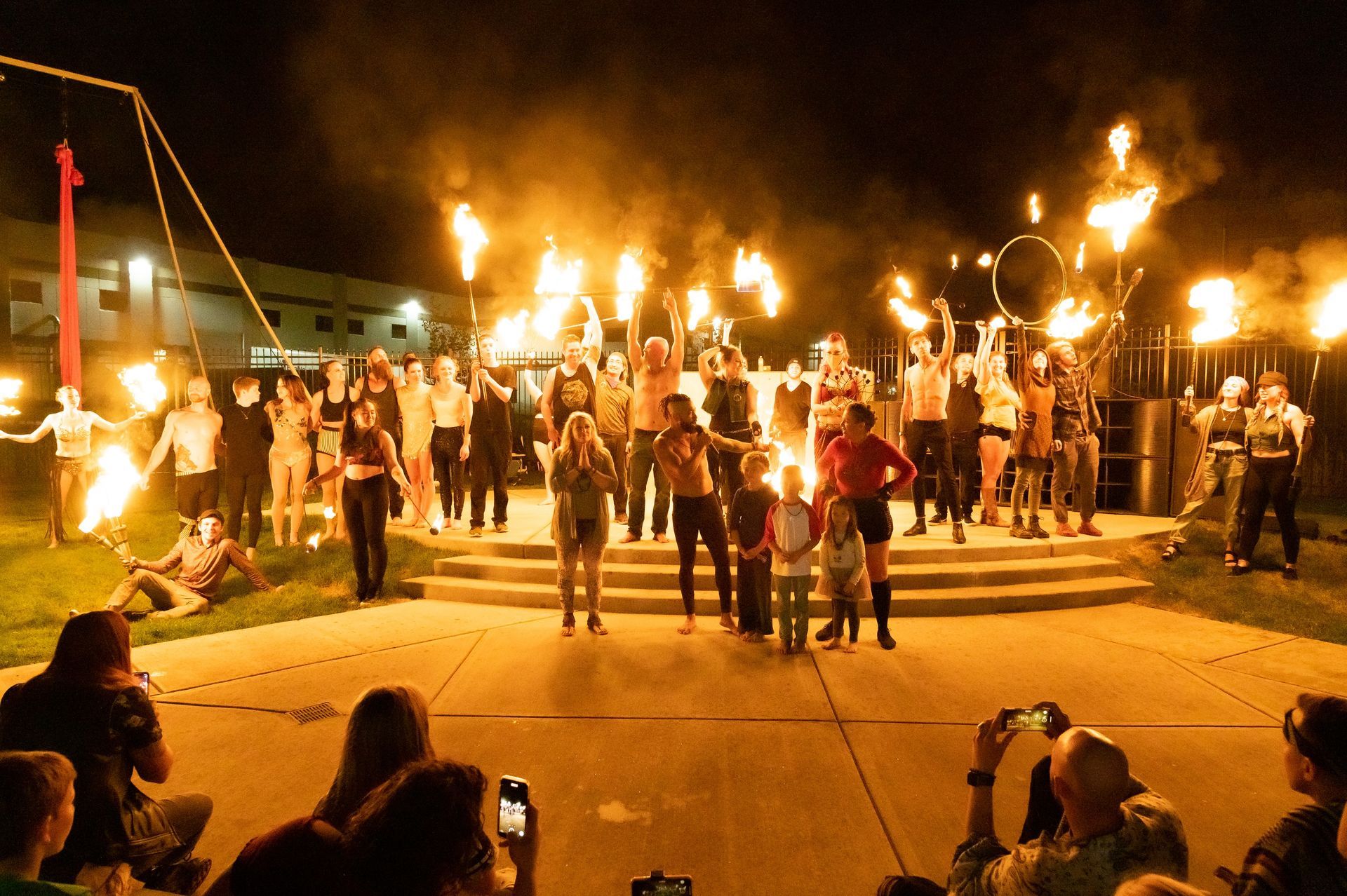 A group of people are standing in front of a fire show.