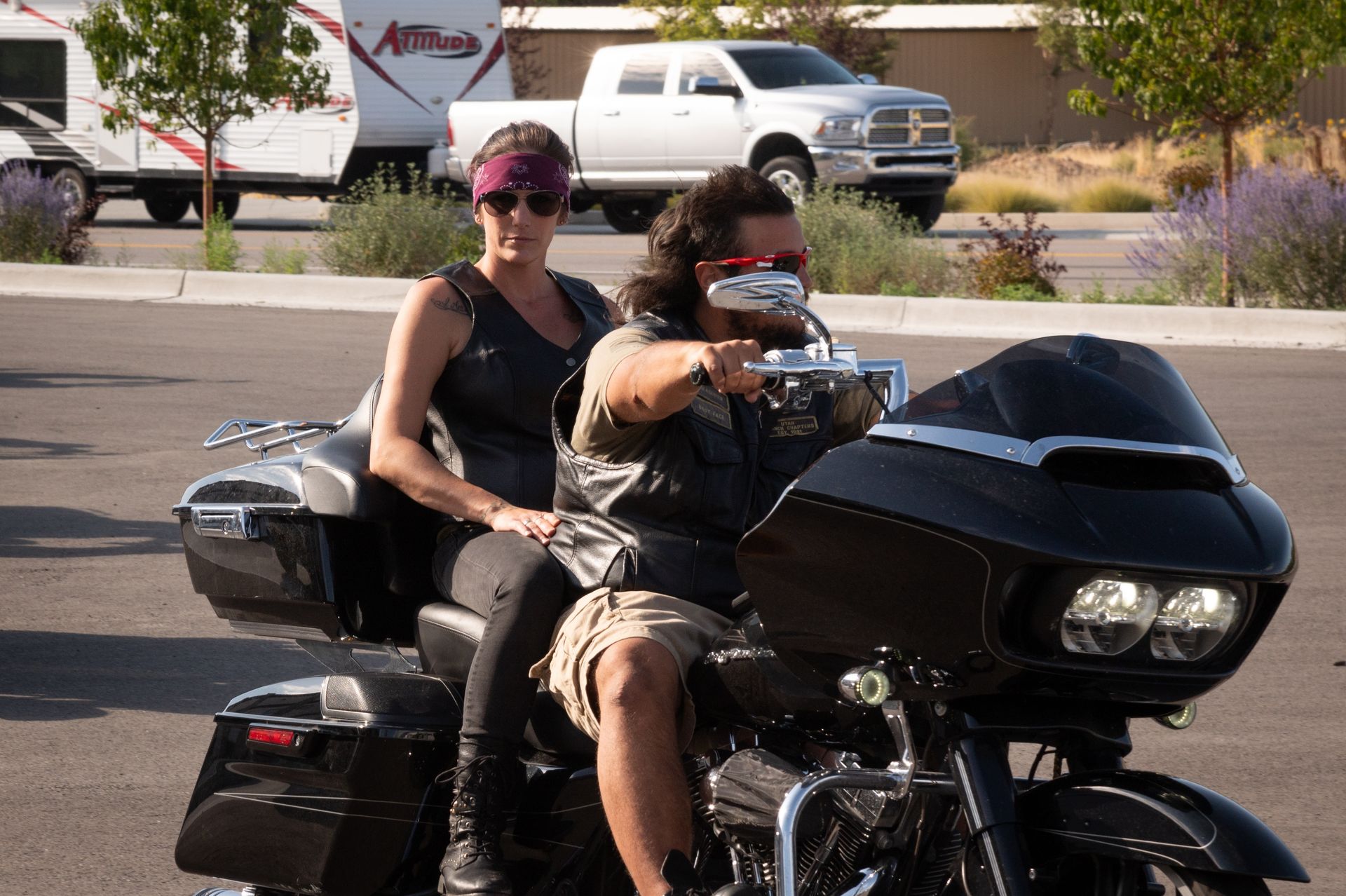 A man and a woman are riding a harley davidson motorcycle