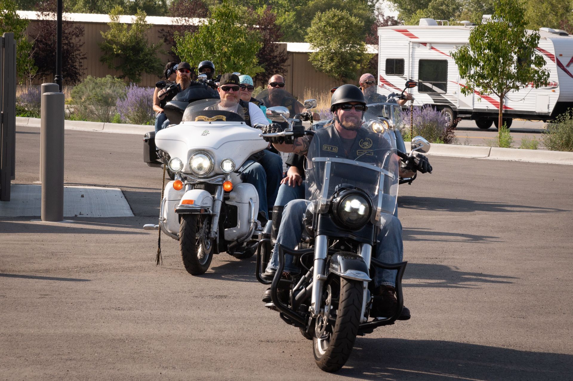 A group of people are riding motorcycles in a parking lot