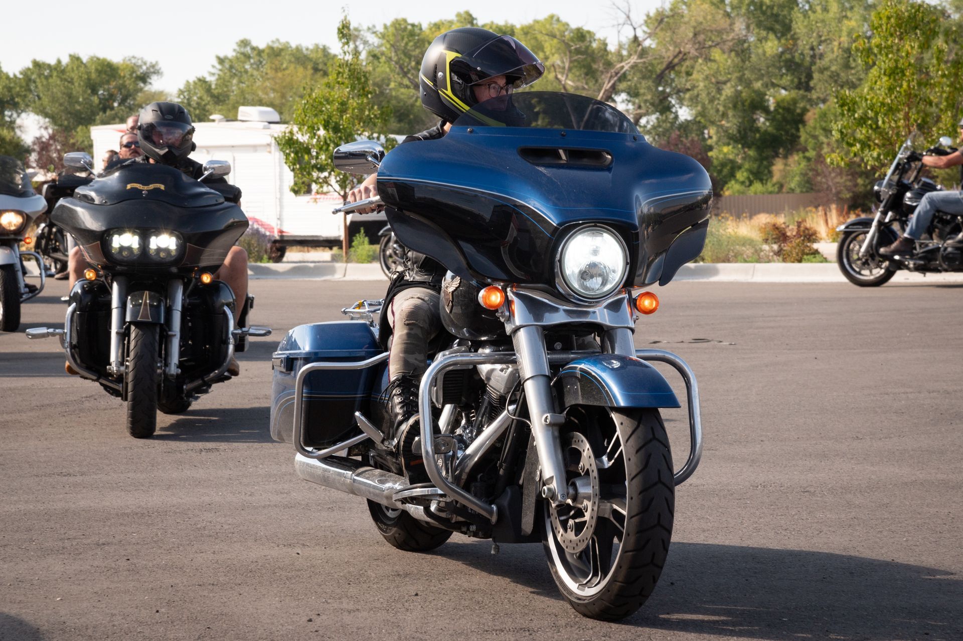 A man is riding a harley davidson motorcycle in a parking lot