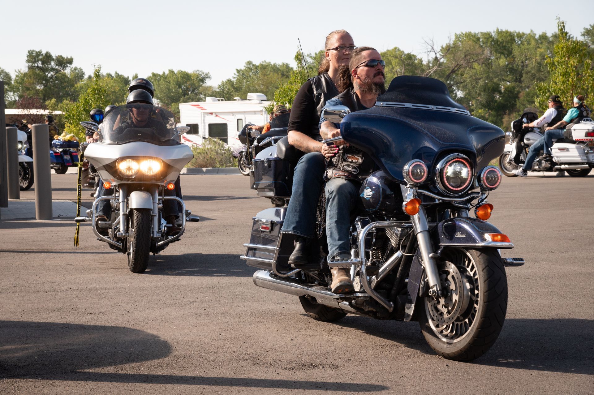 A couple of men riding motorcycles in a parking lot