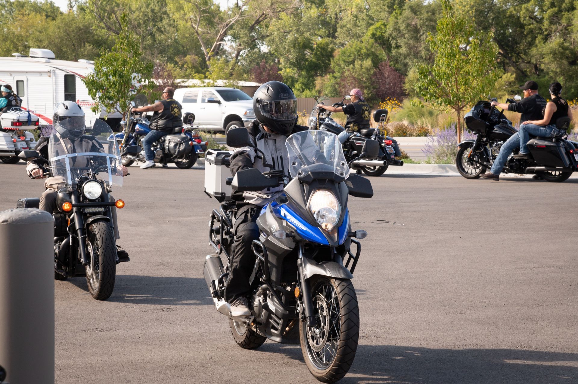A group of people riding motorcycles in a parking lot