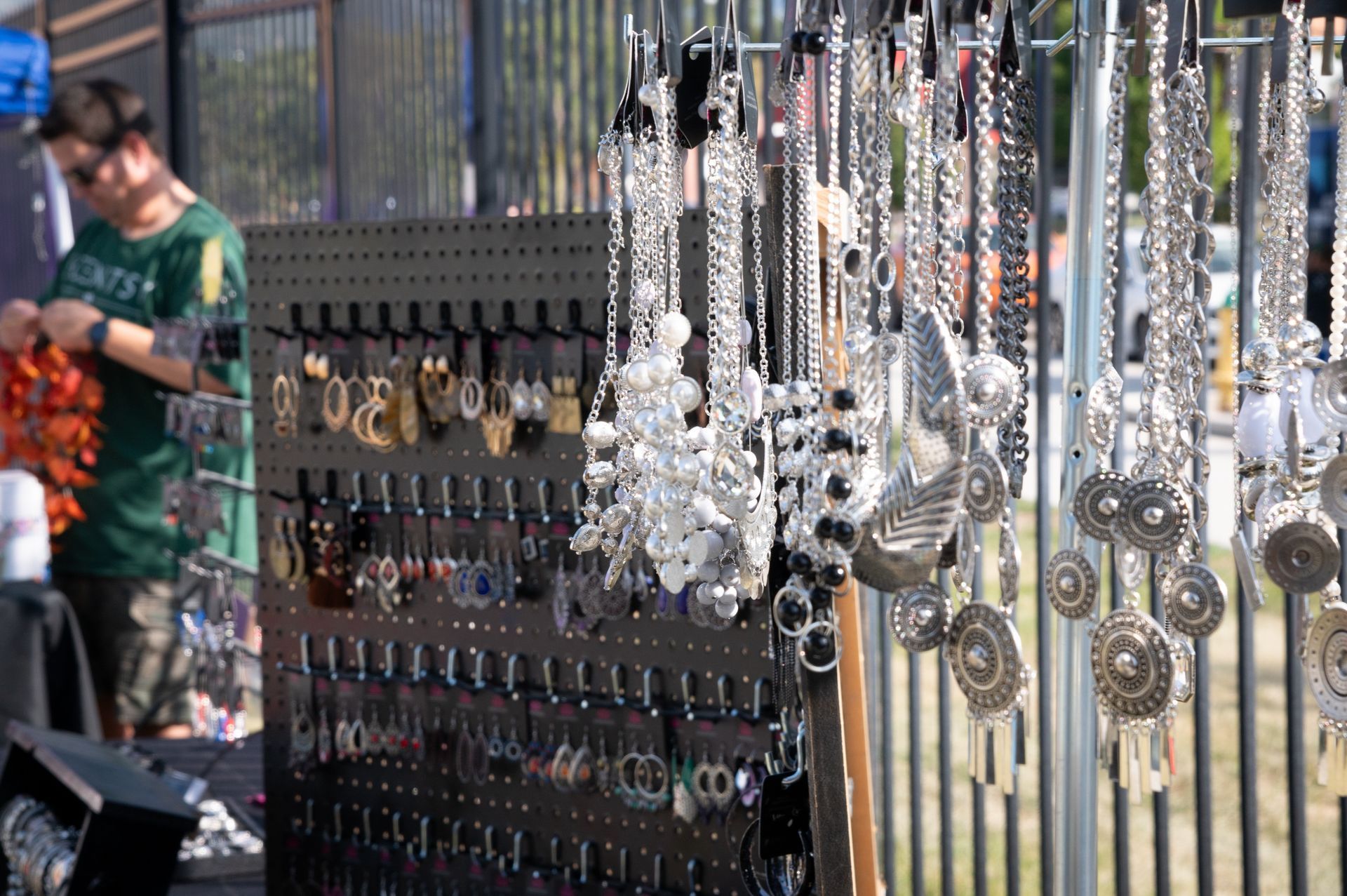 A man is standing in front of a display of jewelry.