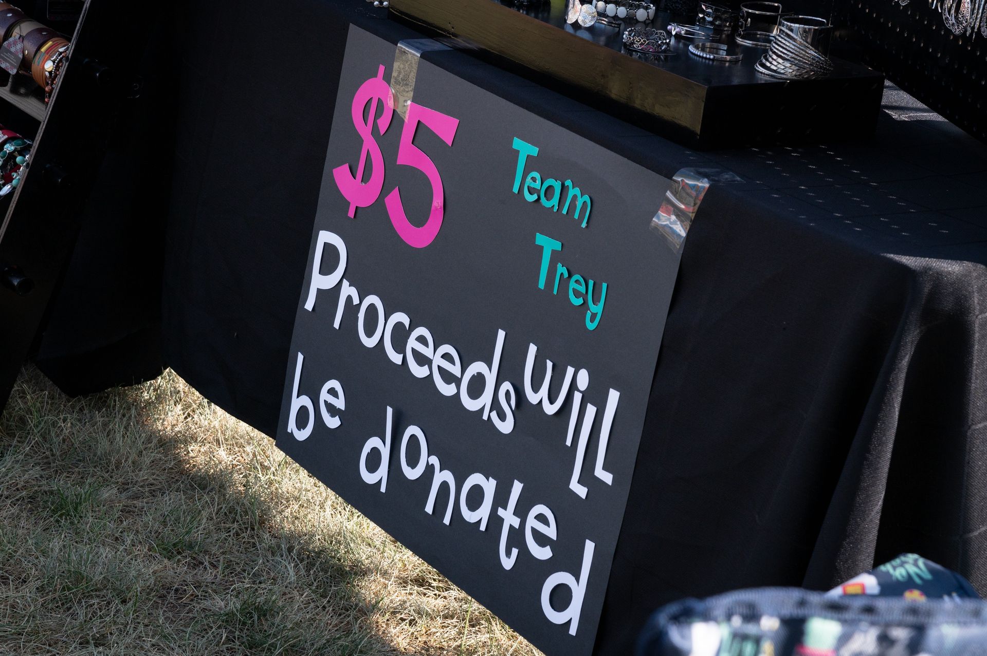 A sign on a table that says $ 5 proceeds will be donated