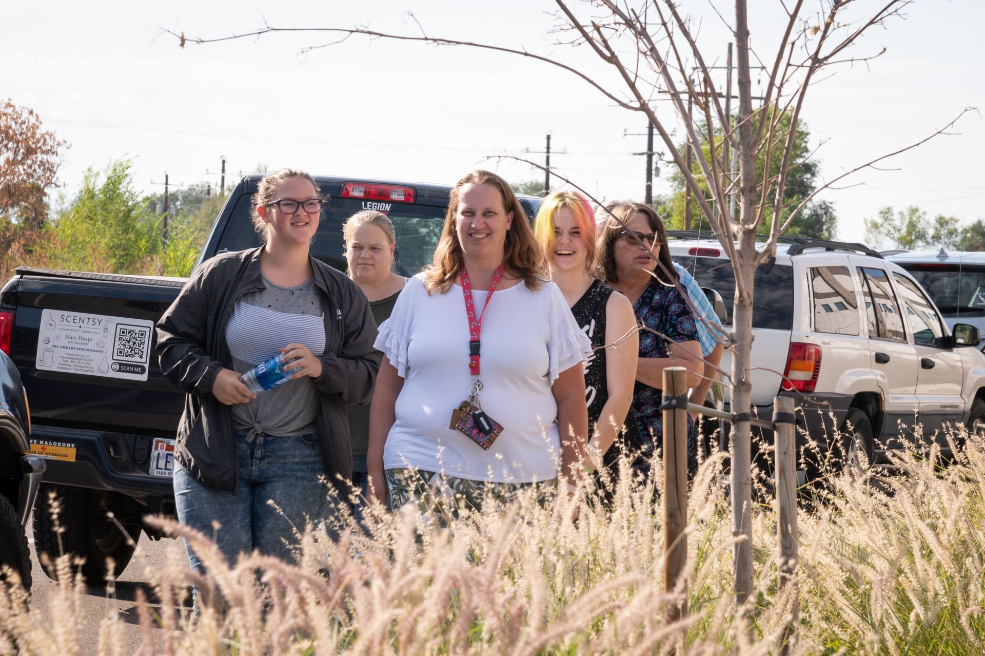 A group of women are posing for a picture in a parking lot.