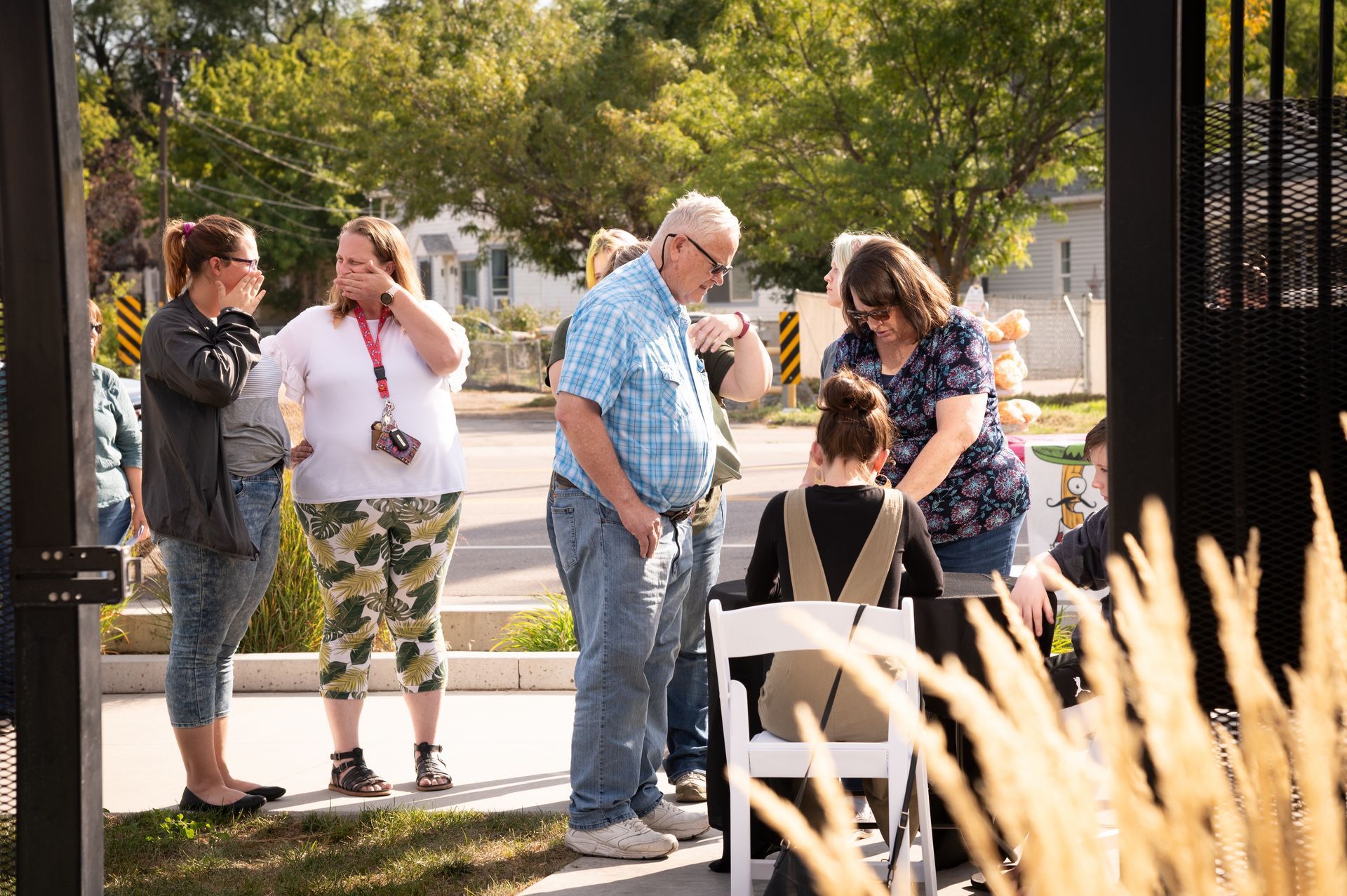 A group of people are standing around a woman sitting in a chair.