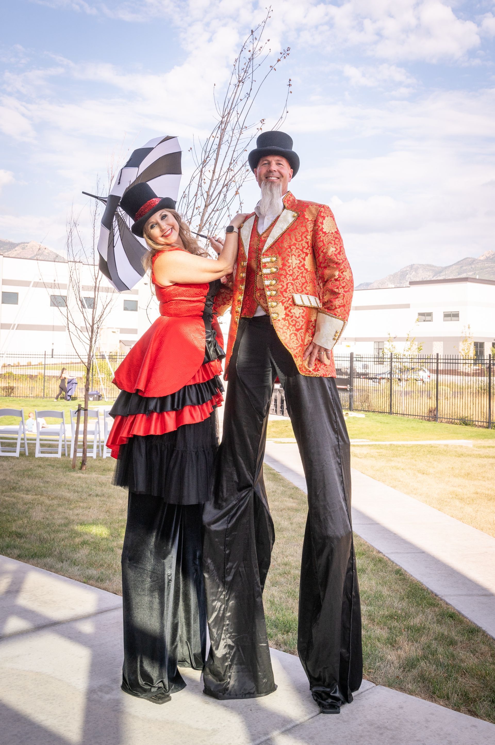 A man and a woman are standing on stilts.