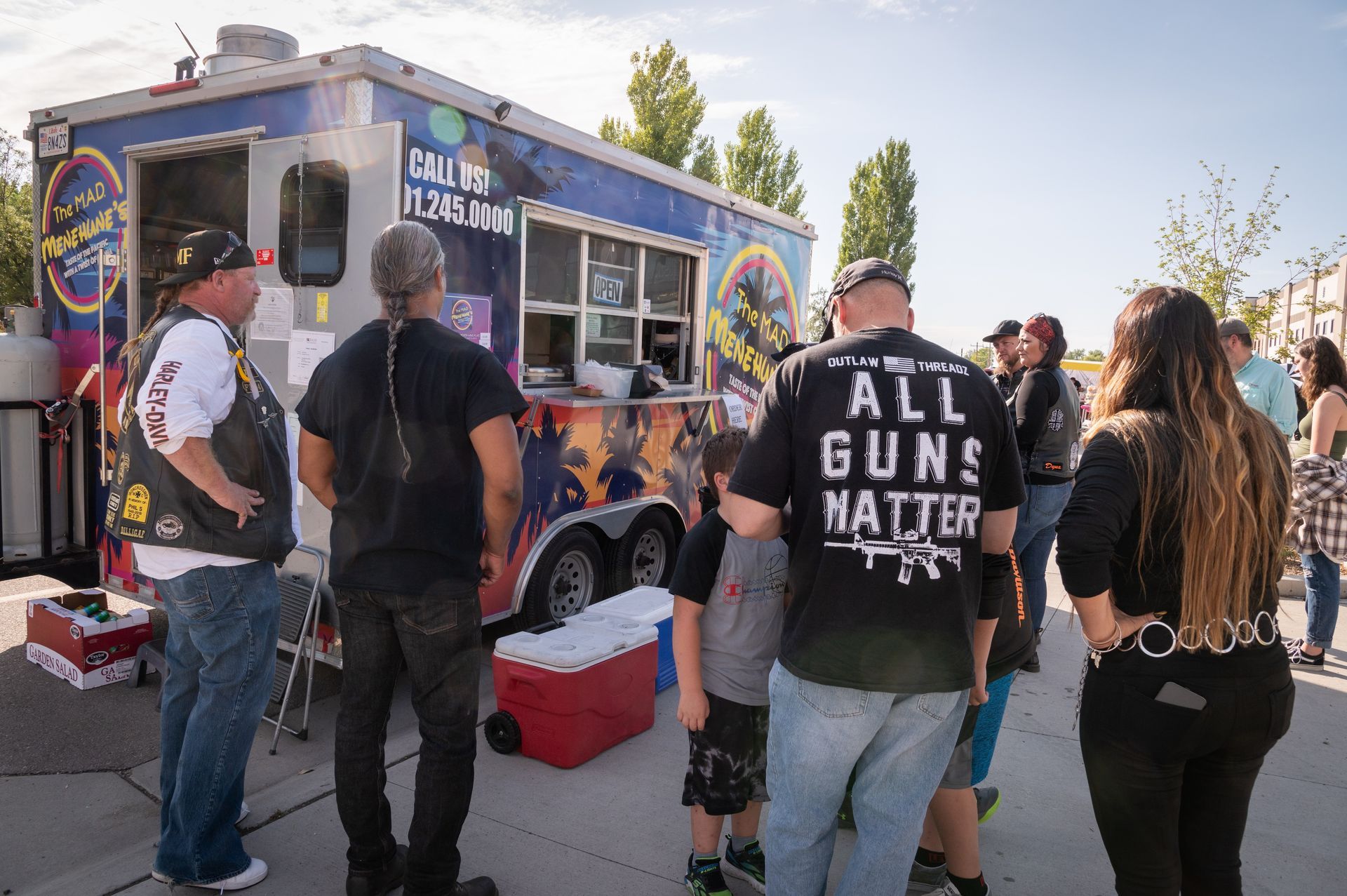 A group of people are standing in front of a food truck.