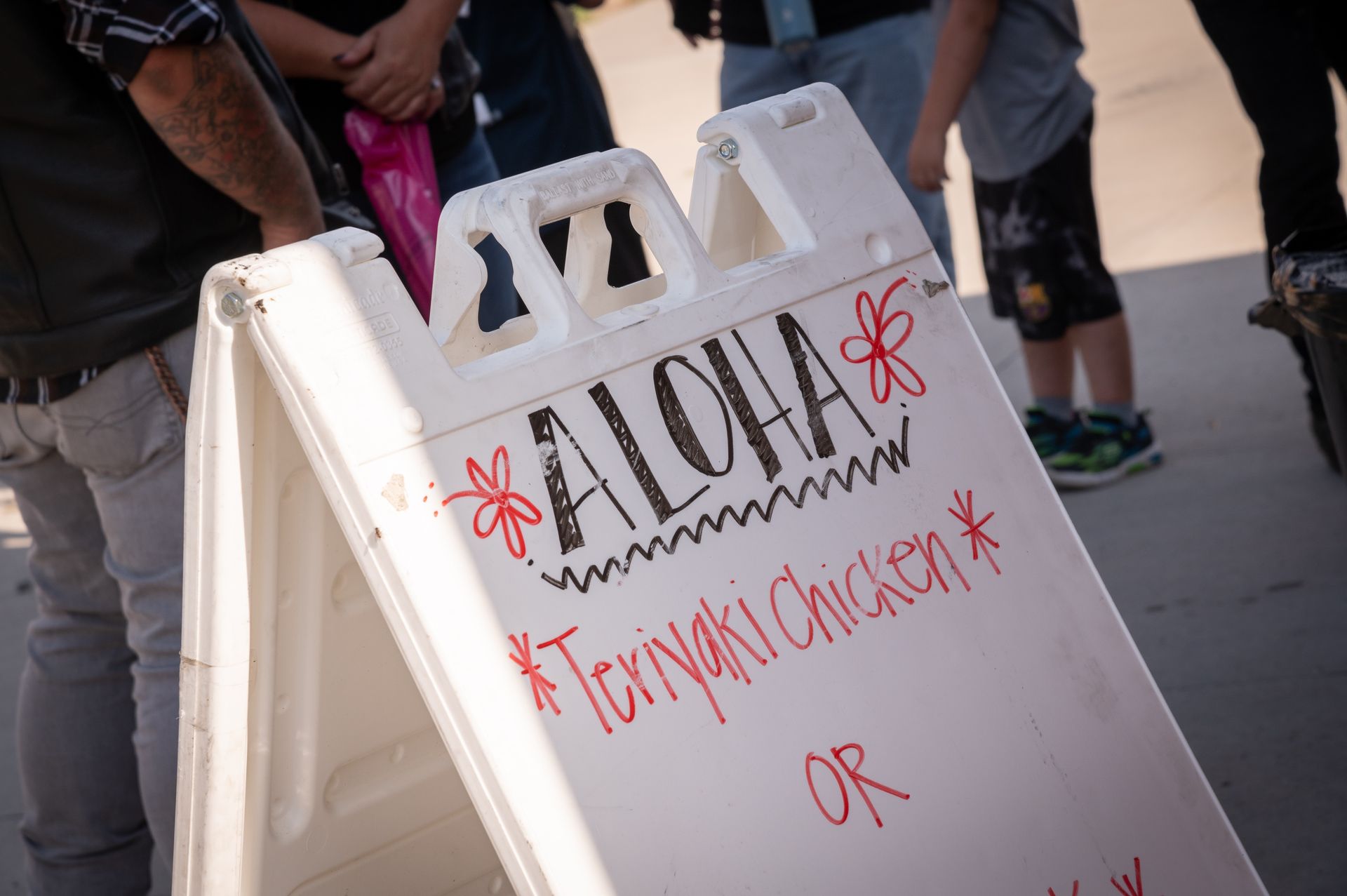 A white sign that says aloha teriyaki chicken on it