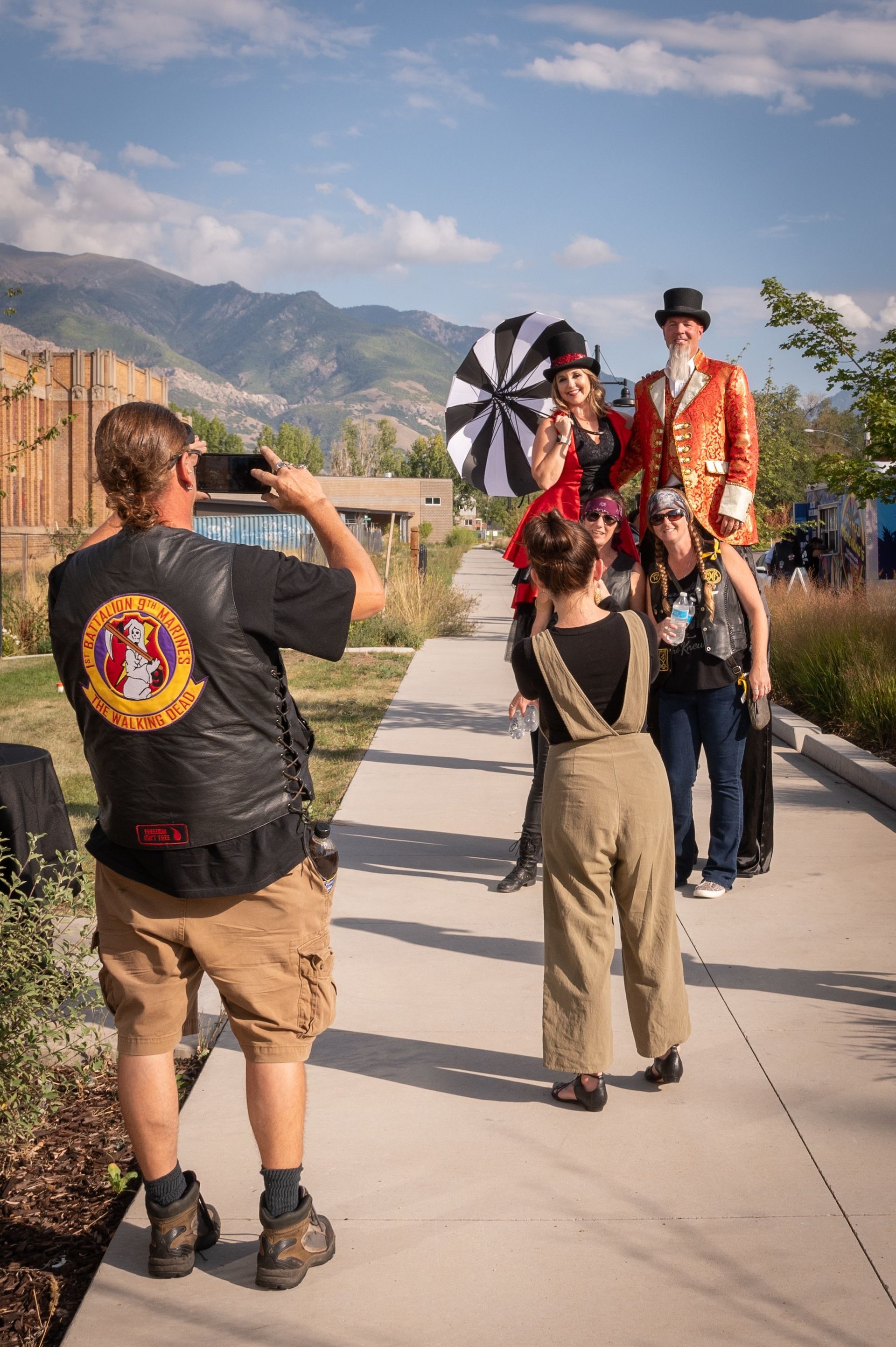 A man is taking a picture of a group of people on stilts.