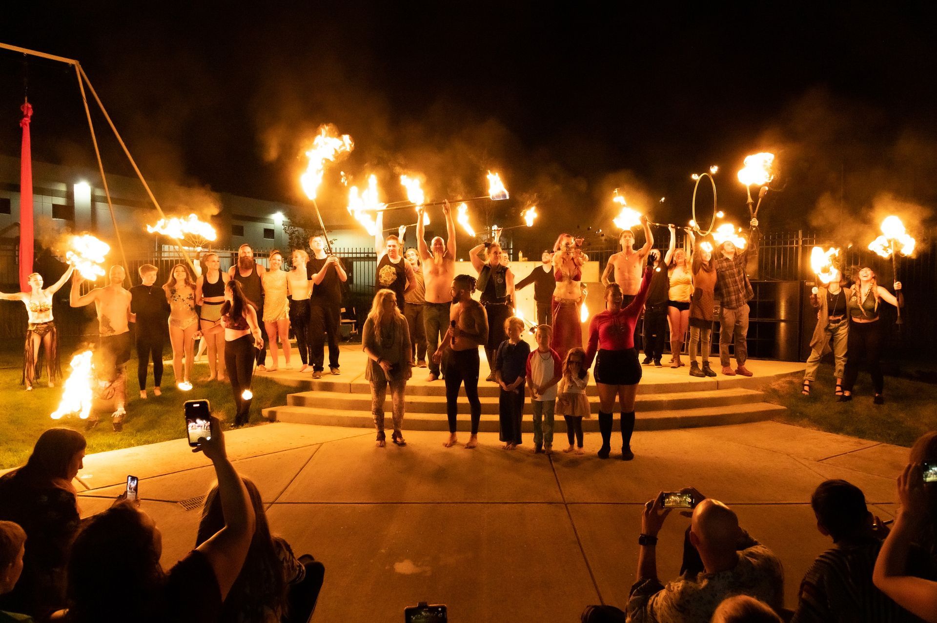 A group of people are standing in front of a fire show.