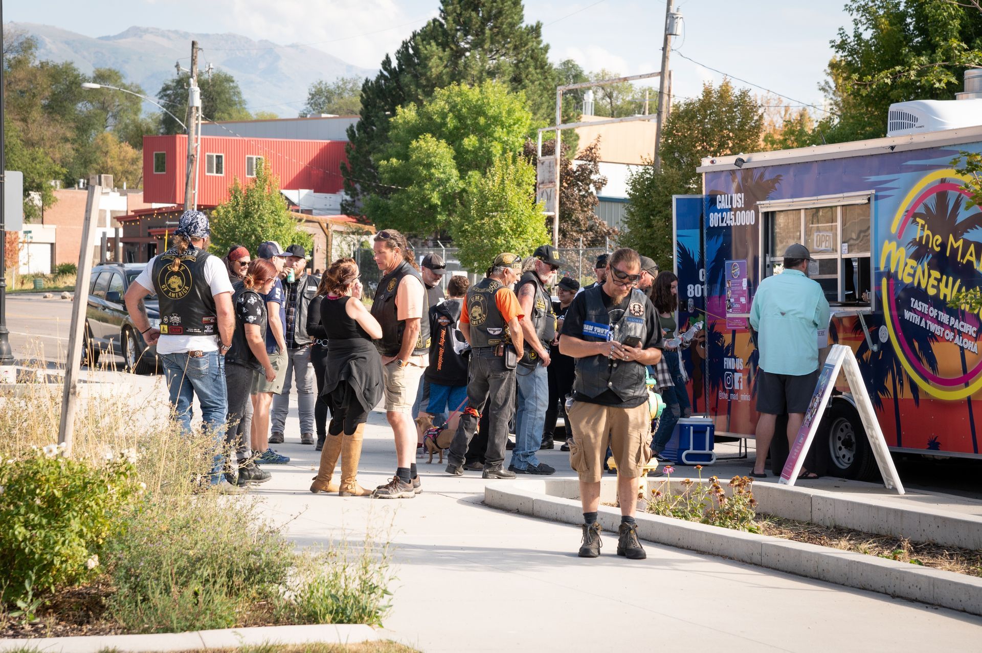 A group of people are standing in front of a food truck.