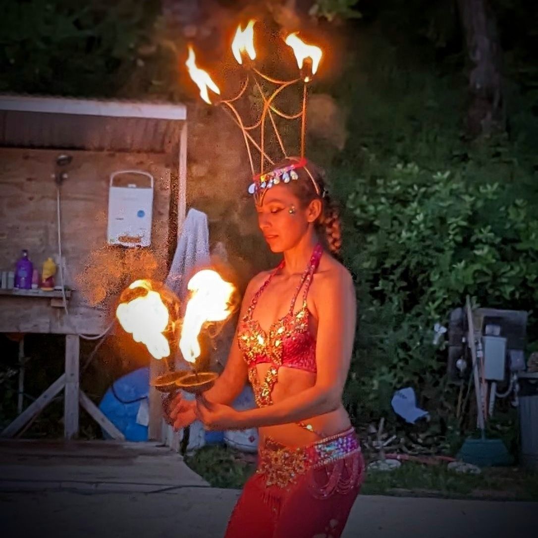 A woman is holding a torch with flames coming out of it.