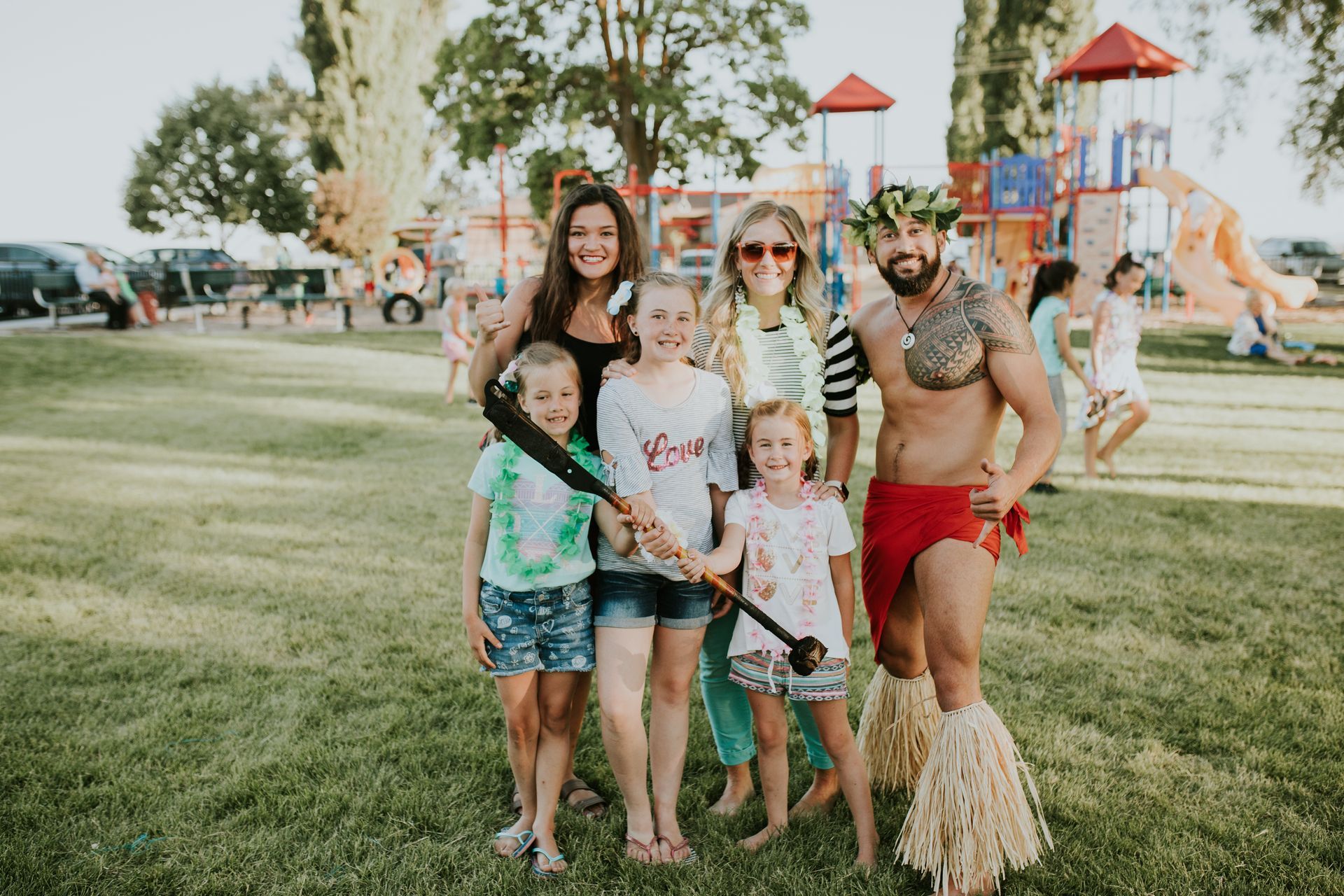 A group of people are posing for a picture in a park.