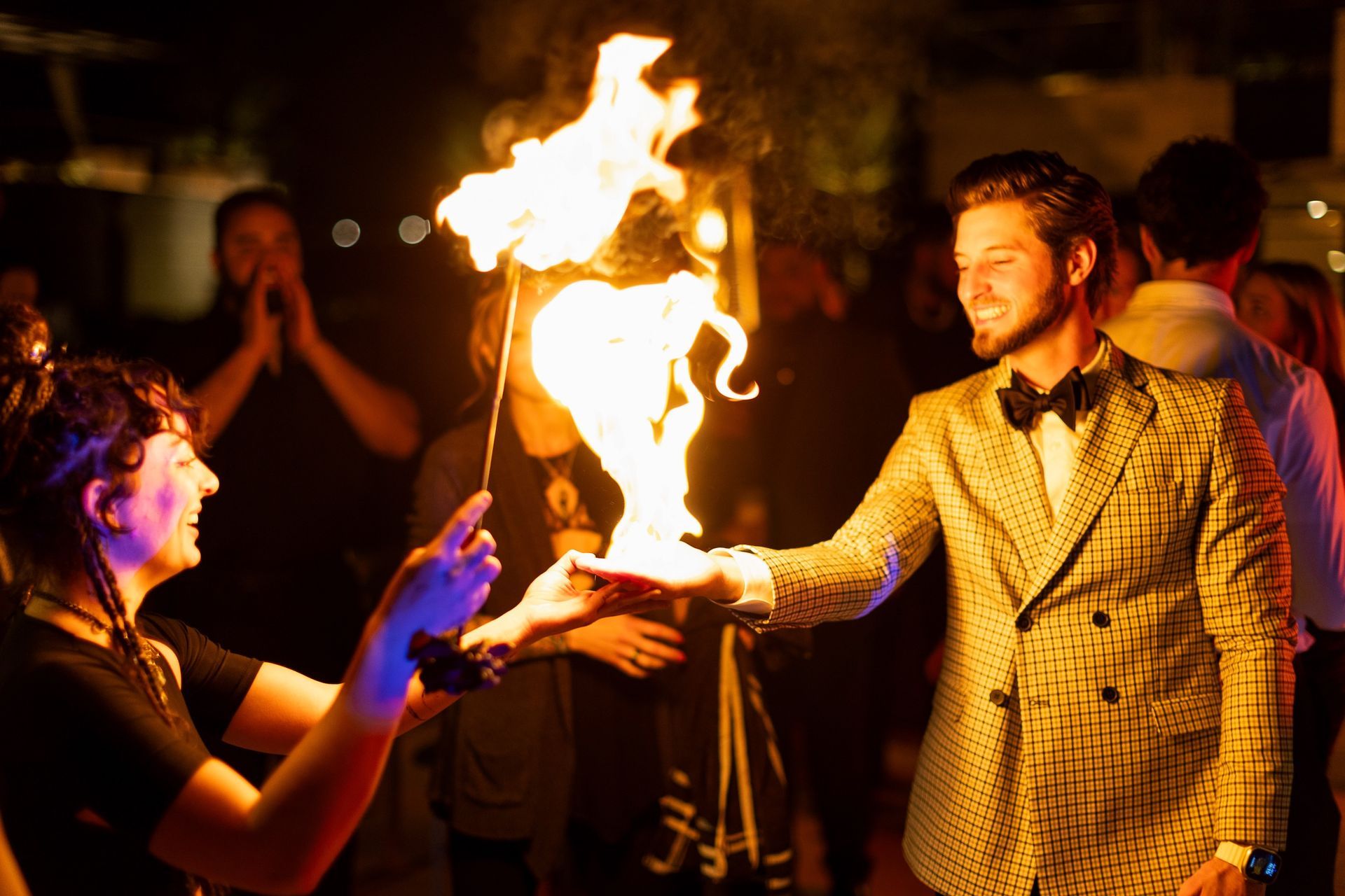 A man in a suit is holding a torch with flames coming out of it.