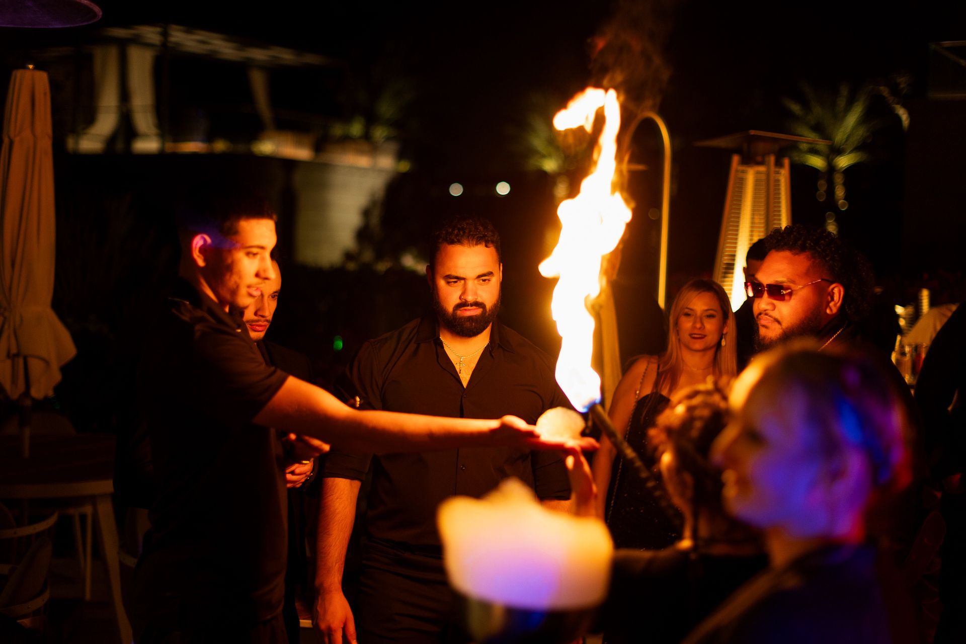 A man is holding a torch in front of a group of people.