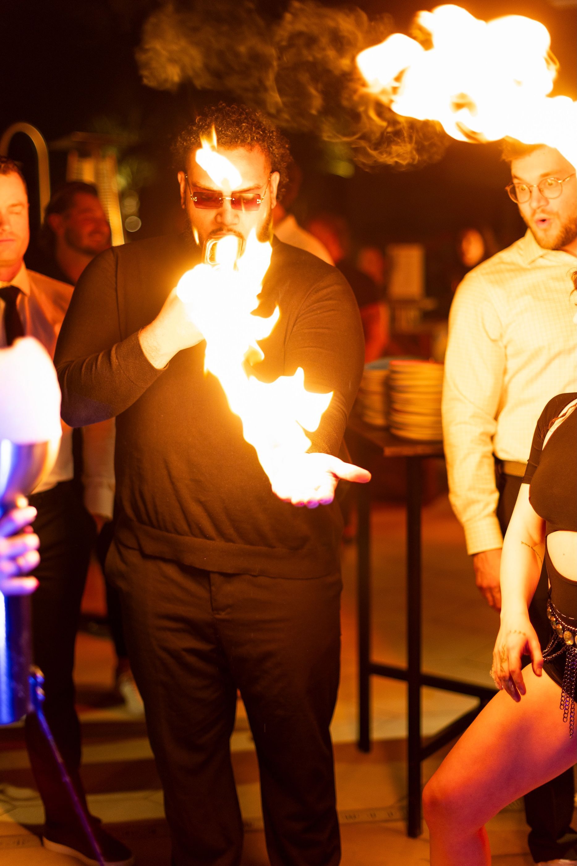 A man is holding a torch with flames coming out of it.