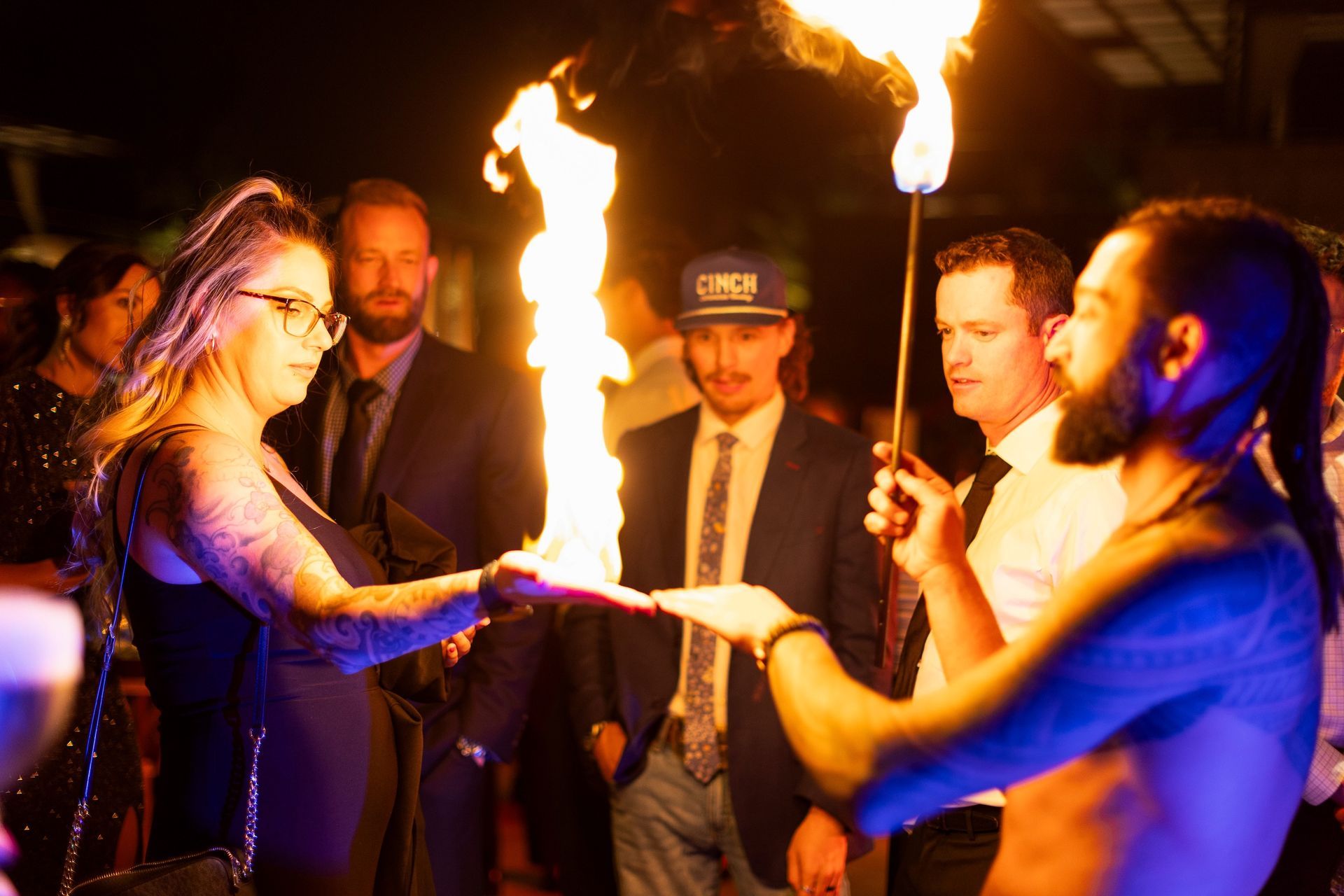 A group of people are standing around a man holding a fire torch.