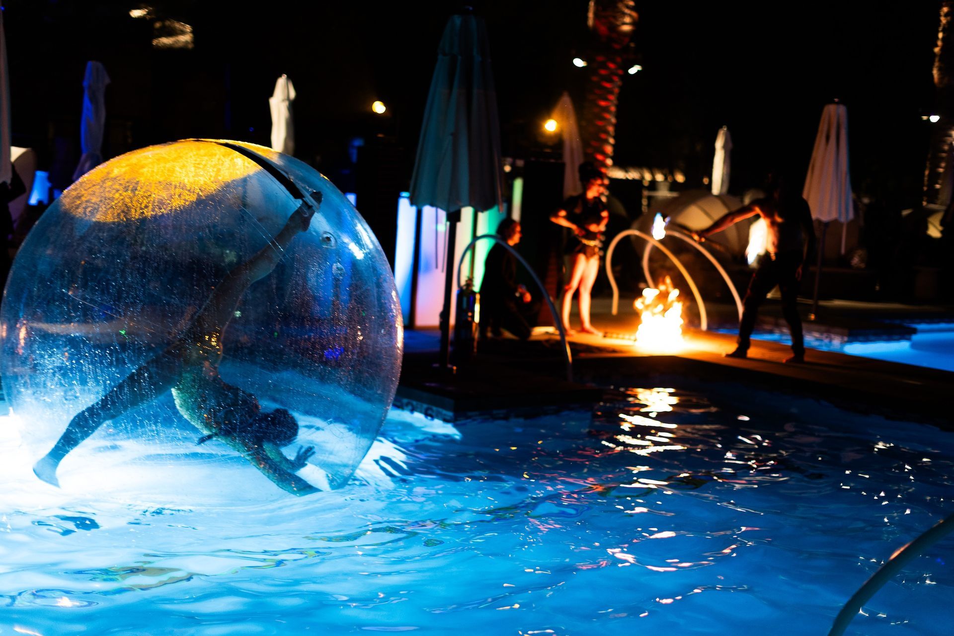 A person is in a bubble in a pool at night