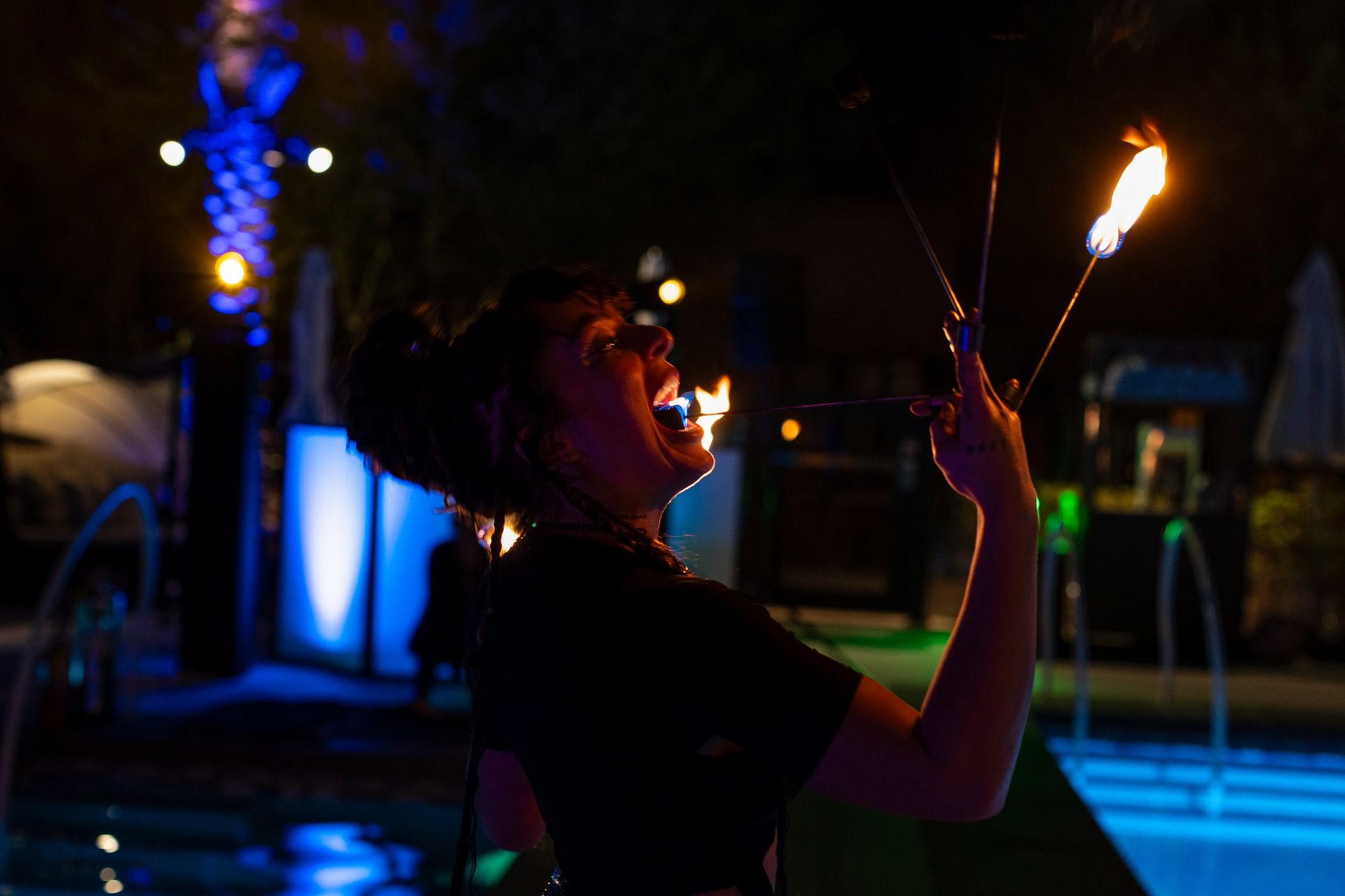 A woman eating fire while performing.