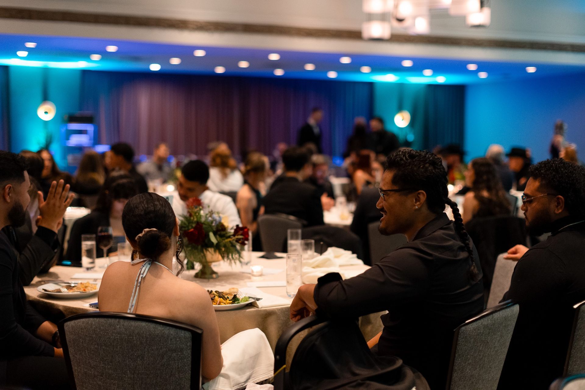 A group of people are sitting at tables in a large room.