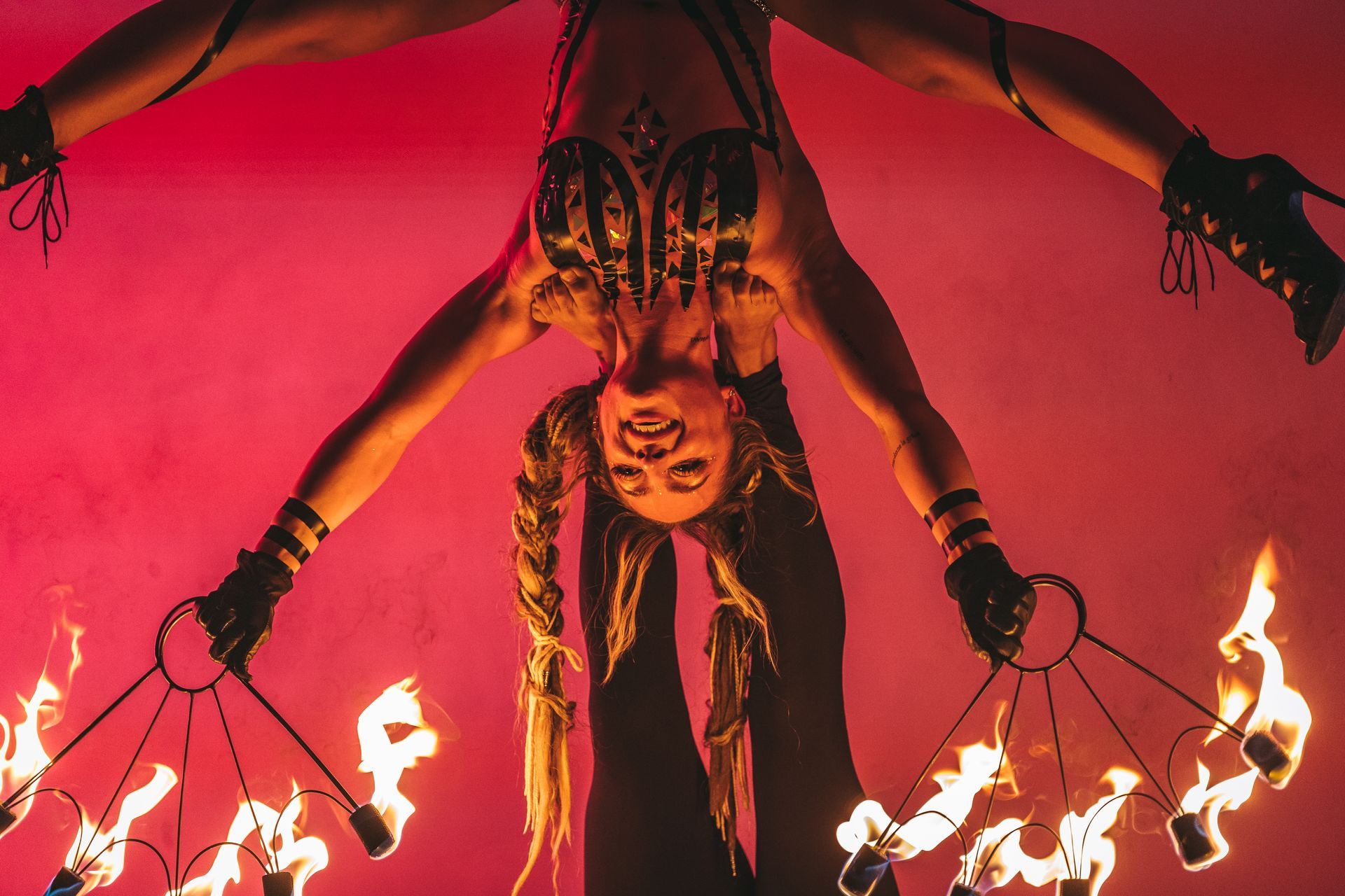 A woman is upside down holding a circle of fire