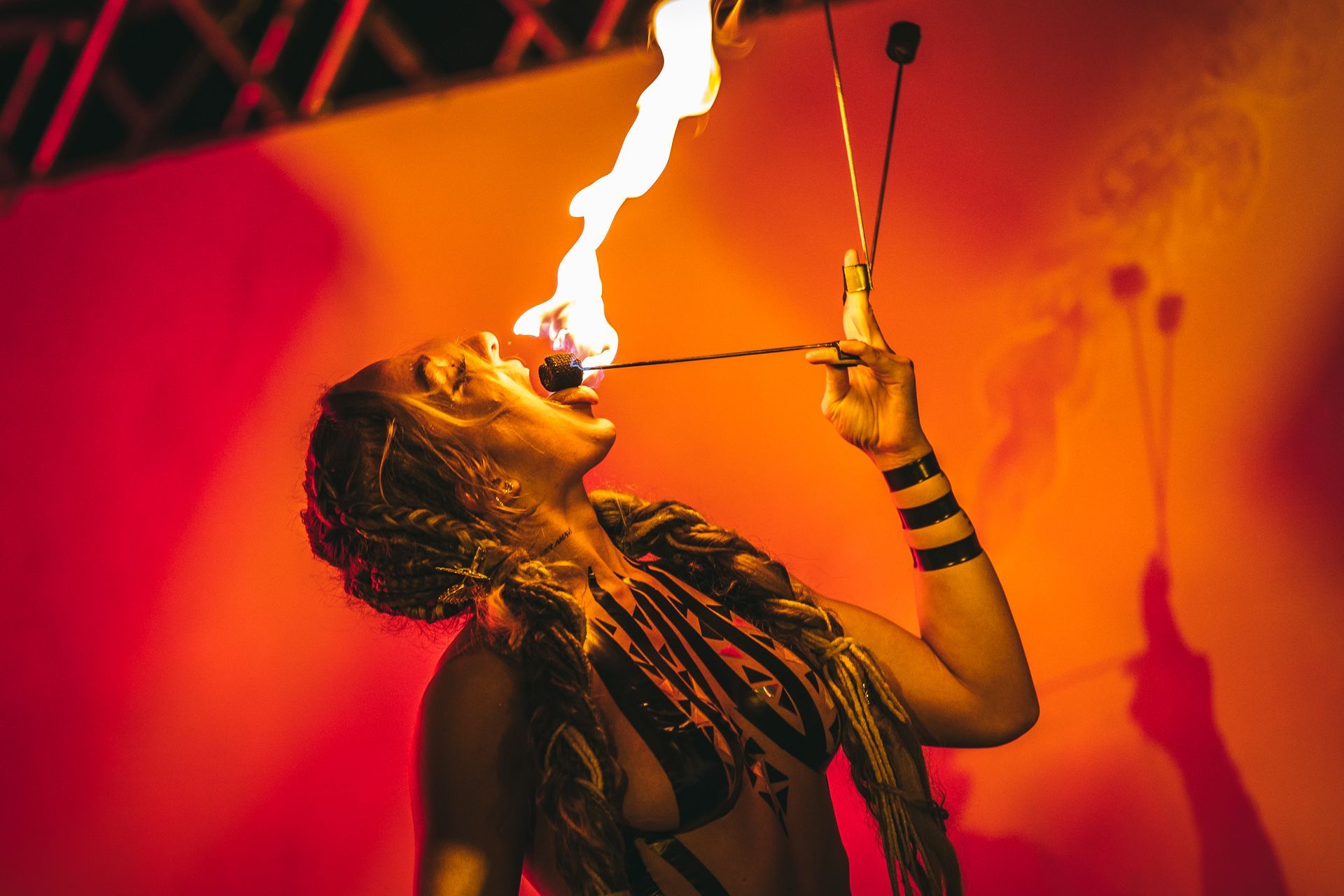 A woman is blowing fire out of her mouth.
