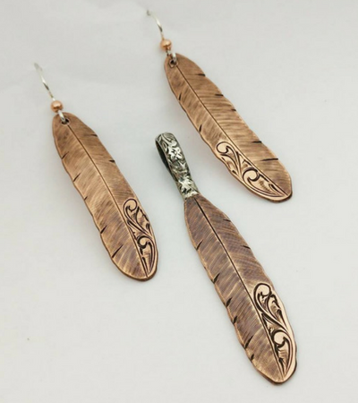 A pair of earrings and a pendant in the shape of feathers