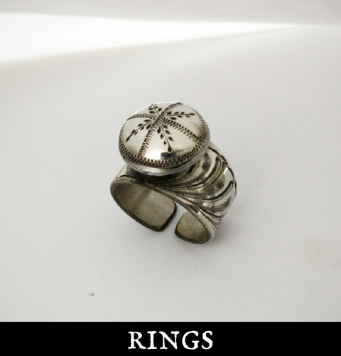 A silver ring is sitting on a white surface under the words rings