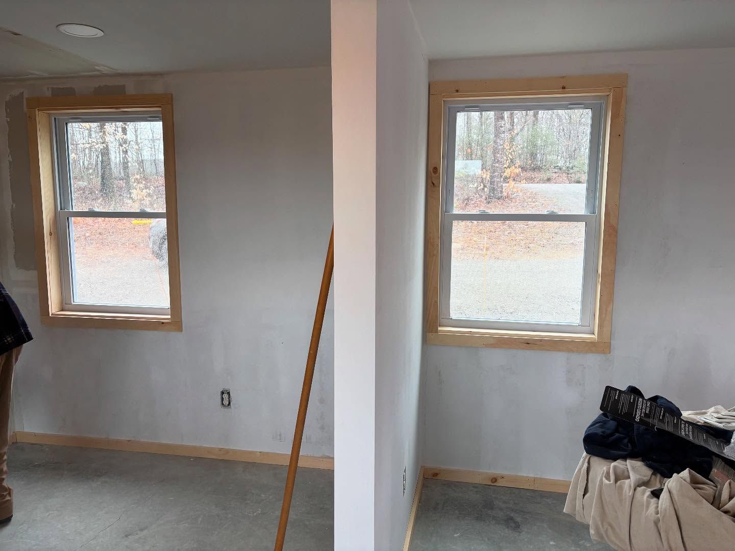 Two windows with wood trim, in a room with white walls.