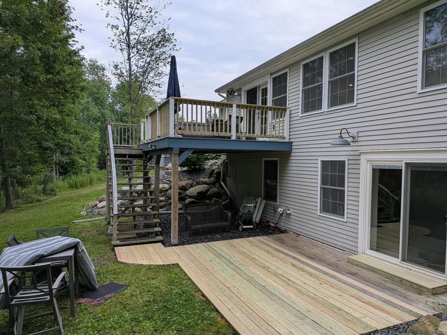 Wooden deck with stairs and a second-story deck attached to a two-story house.