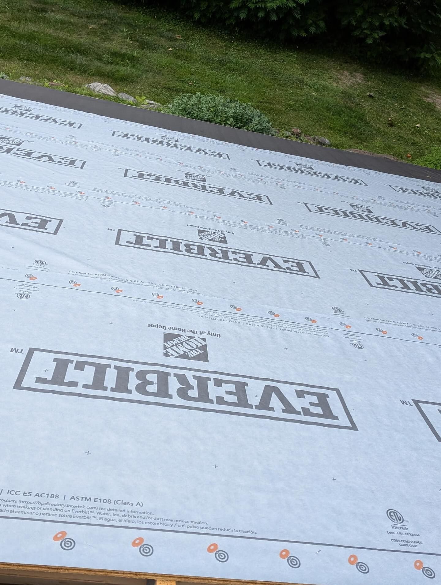 Everbilt brand roofing underlayment on a rooftop, with a green background.