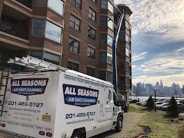 A white van is parked in front of a tall building.