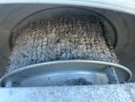 A close up of a dirty air filter with a lot of dust on it.
