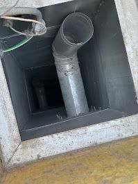 A metal pipe is coming out of a hole in a wall.