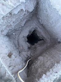 A close up of a dirty dryer duct with a hole in it.
