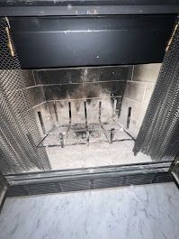 A close up of a fireplace with smoke coming out of it.