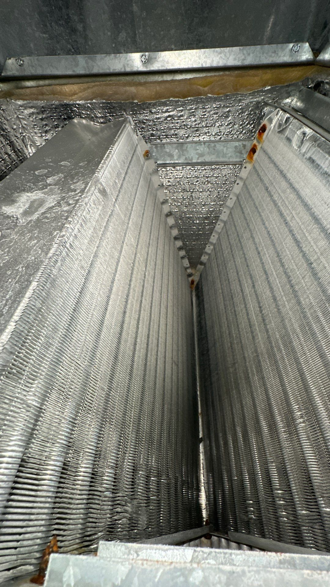 A close up of an air conditioner coil with aluminum foil on it.